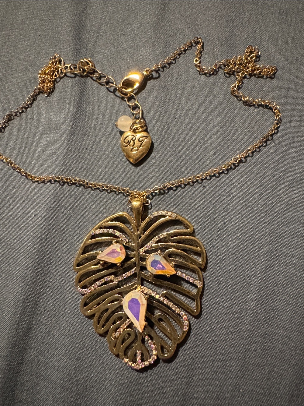 Betsey Johnson Gold Monstera Leaf Necklace with Iridescent Pink-Purple Teardrops